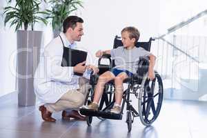 Doctor interacting with disable boy in corridor