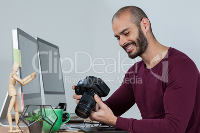 Photographer reviewing captured photos in his dslr camera