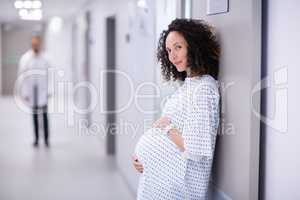 Portrait of pregnant woman standing in corridor