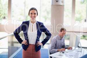 Happy and confident businesswoman standing with hands on hip