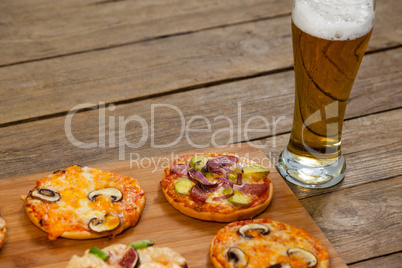 Delicious pizza served on wooden board with a glass of beer