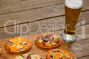 Delicious pizza served on wooden board with a glass of beer