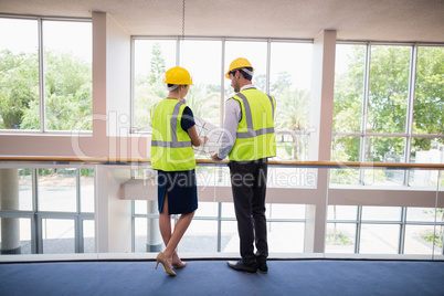 Architects discussing over blueprint