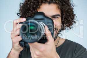 Male photographer with digital camera in studio