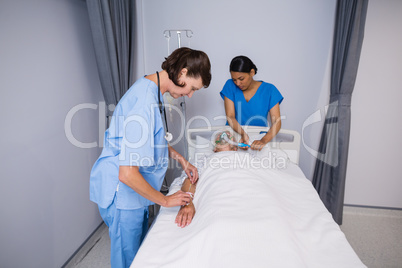 Doctor and nurse examining senior patient in ward