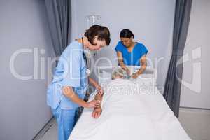 Doctor and nurse examining senior patient in ward