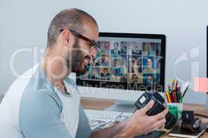 Male photographer reviewing captured photos in his digital camera