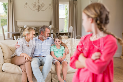 Girl looking at back at family sitting on sofa