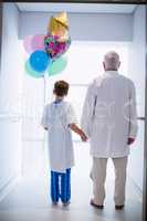 Doctor walking with patient in hospital corridor