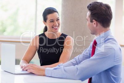 Business executives sitting with laptop at desk