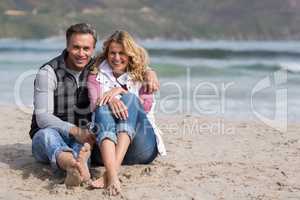 Mature couple sitting together on the beach