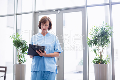Nurse writing on clipboard