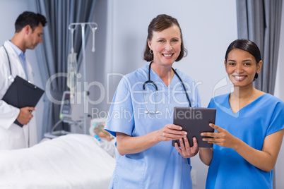 Portrait of smiling doctor and nurse holding digital tablet