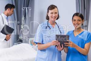 Portrait of smiling doctor and nurse holding digital tablet