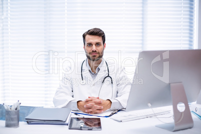 Portrait of male doctor sitting at desk