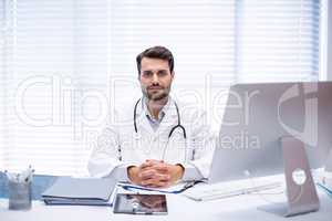 Portrait of male doctor sitting at desk