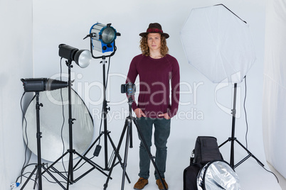 Photographer with hands in pocket standing in the photo studio