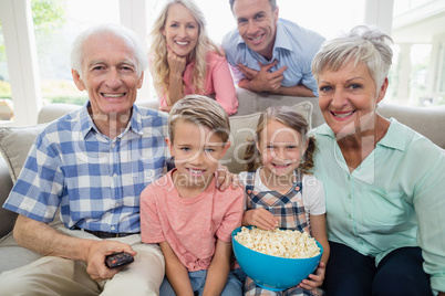 Happy multi-generation family watching television in living room