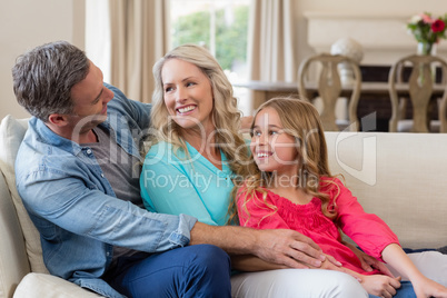 Parents and daughter having fun in living room