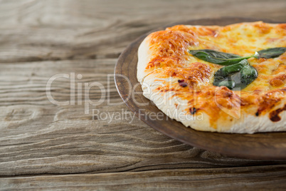 Italian pizza served in a tray on a wooden plank