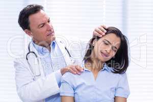 Doctor examining female patients neck