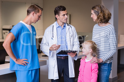 Doctors discussing medical report with mother and daughter