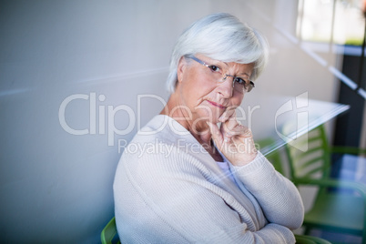 Thoughtful senior woman sitting on chair