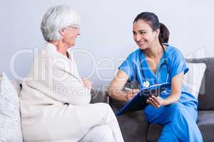 Doctor and senior woman discussing on clipboard
