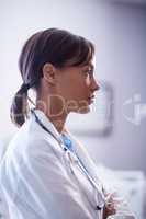 Thoughtful female doctor with stethoscope in ward