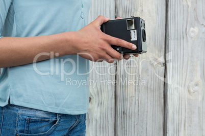 Mid section of female photographer holding old fashioned camera