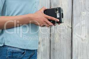 Mid section of female photographer holding old fashioned camera