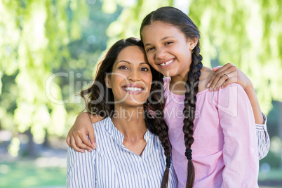 Mother embracing her daughter in park