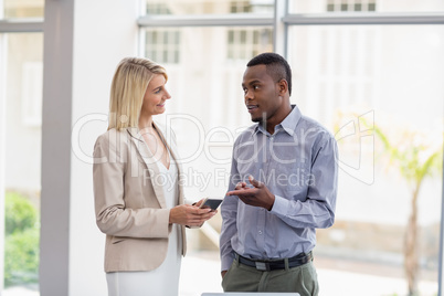 Business executives discussing over mobile phone Business executives discussing over mobile phone