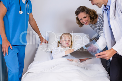 Doctors showing x-ray to patient and mother