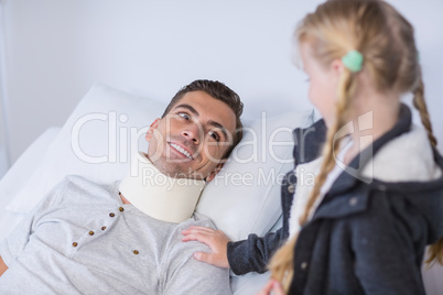 Smiling daughter comforting her sick father