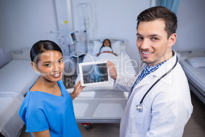 Portrait of smiling doctor and nurse using digital tablet