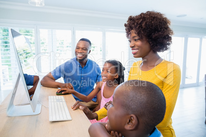 Happy family using computer in living room