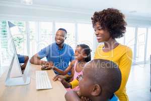 Happy family using computer in living room