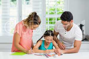 Parents and daughter drawing in kitchen