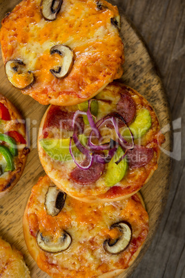 Various types of pizza arranged on a wooden tray