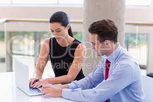 Business executives using laptop at desk