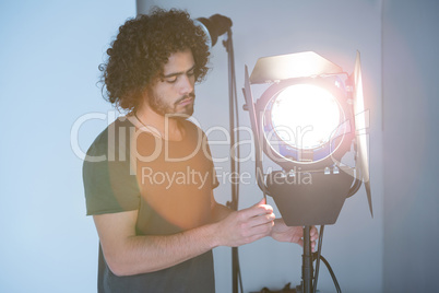 Male photographer adjusting spotlight