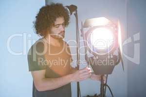 Male photographer adjusting spotlight