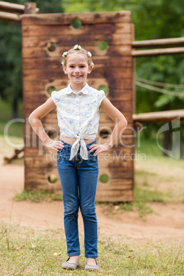 Portrait of a girl standing with hands on hip in park