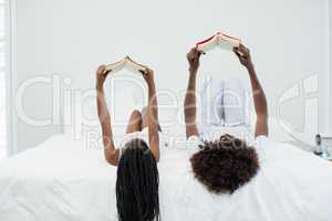 Mother and daughter reading novel in bedroom