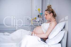Pregnant woman relaxing on hospital bed