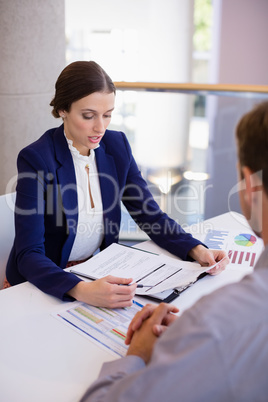 Businesswoman working at desk with colleague