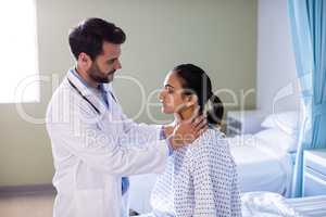 Doctor examining patients neck in hospital