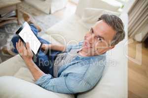 Man sitting on sofa and using digital tablet in living room