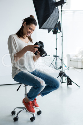 Female photographer reviewing captured photos in her digital camera